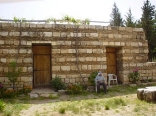 A man sitting in front of his house