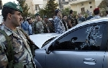 Lebanese security forces surround the bullet-riddled car of assasinated Lebanese Industry Minister Pierre Gemayel